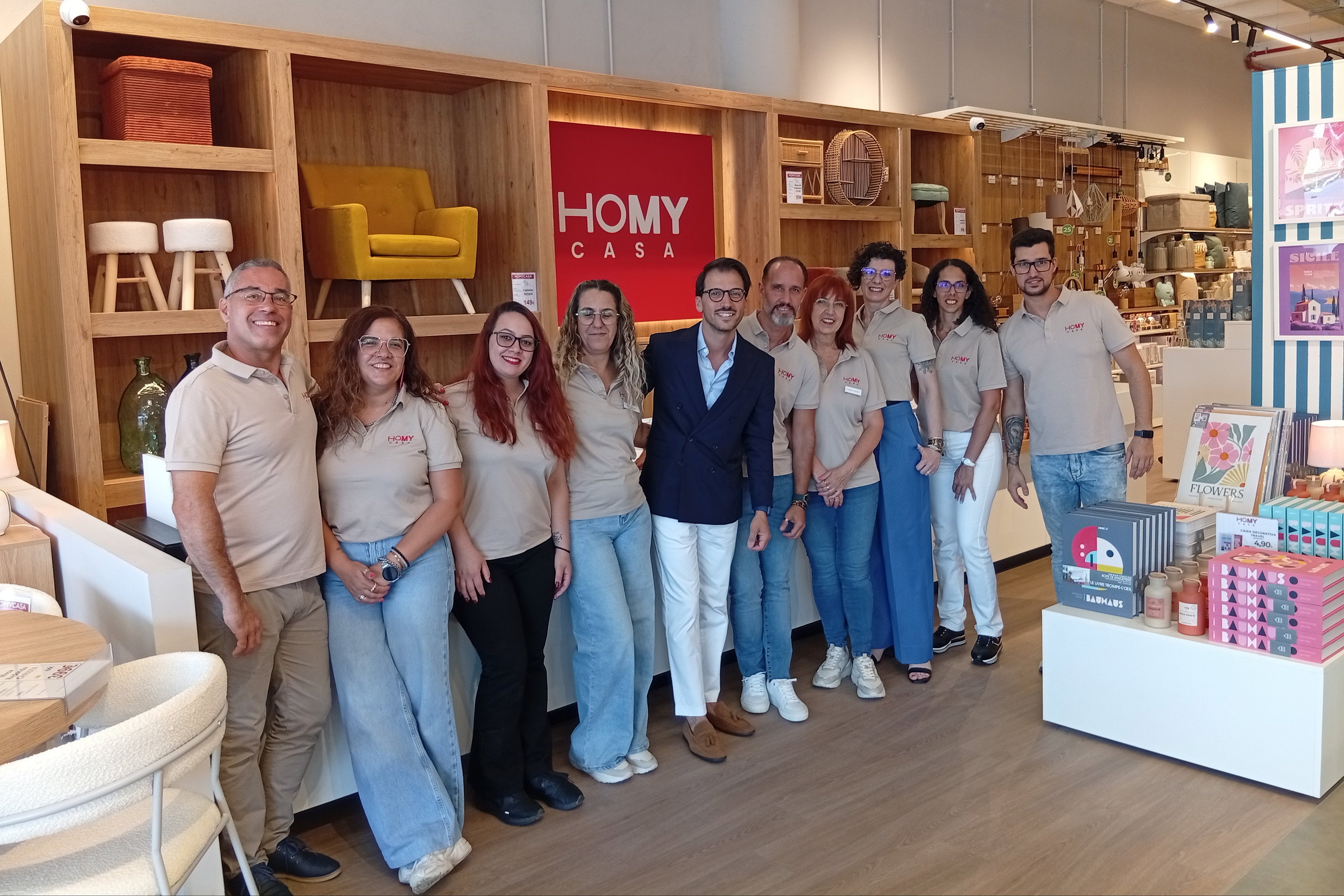 Equipa da loja HOMYCASA reunida no interior da loja, junto à zona de atendimento e exposição.